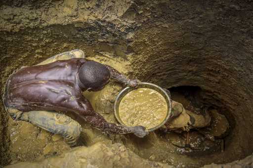 FILE- Miners extract mud they hope contains gold at a gold mining site at which adults and youth wo…