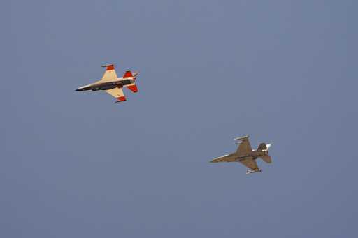 An AI-enabled Air Force F-16 fighter jet, left, flies next to an adversary F-16, as both aircraft r…