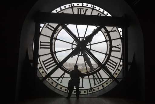 A visitor looks through the clock of the Orsay museum, overlooking Paris, October 16, 2014