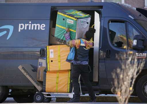An Amazon Prime delivery person lifts packages while making a stop at a high-rise apartment buildin…
