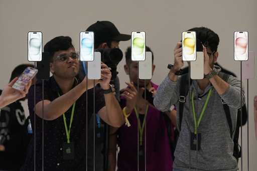 File - People look at iPhone 15 phones at an announcement of new products in Cupertino, Calif