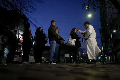 A priest blesses those visiting the Church of San Cayetano, the patron Saint of work, on his feast …