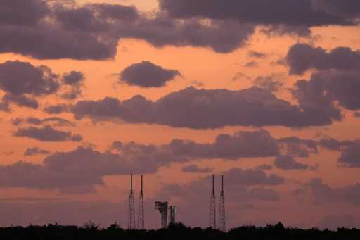 Boeing's Starliner capsule, atop an Atlas V rocket, sits on the launch pad during sunrise at Space …
