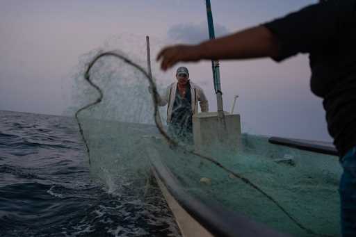 Fisherman Mauricio Contreras casts his nets alongside his daughter at sea near Los Arrecifes, Mexic…