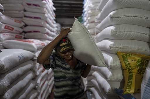 A worker carries a bag of rice at a warehouse in Ho Chi Minh City, Vietnam, Tuesday, January 30, 20…