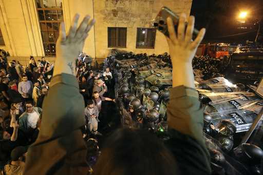 Police block protestors gathered outside the parliament building in Tbilisi, Georgia, on Tuesday, A…