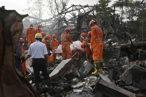 National Disaster Response Force rescuers carry the dead body of a person after an explosion and fi…