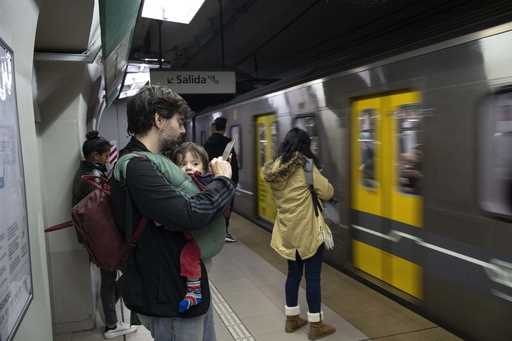 Commuters wait to board a subway car, in Buenos Aires, Argentina, Friday, May 17, 2024