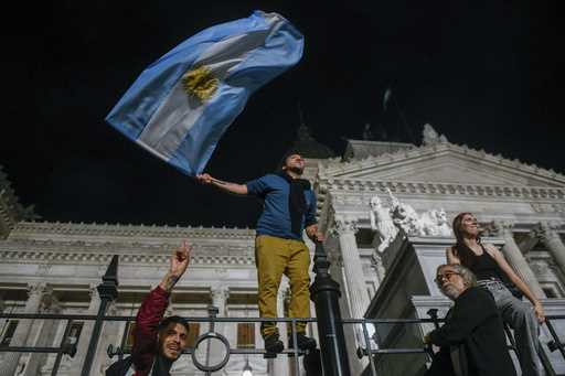 Demonstrators climb to the fence of Congress during protests against economic measures announced by…
