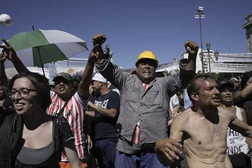 People rally outside Congress during a national strike against the economic and labor reforms propo…