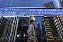 A pedestrian passes by the Hong Kong Stock Exchange electronic screen in Hong Kong, on Wednesday, M…