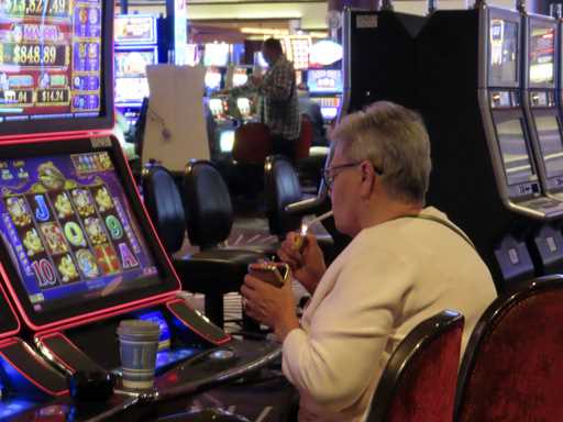 A gambler lights a cigarette at a slot machine in Harrah's casino in Atlantic City N