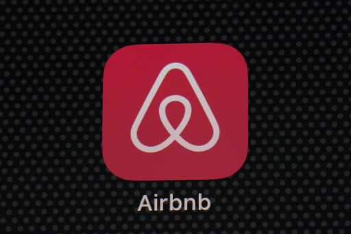 The Airbnb app icon is displayed on an iPad screen in Washington, D