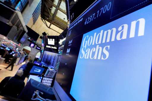 In this December 13, 2016, file photo, the logo for Goldman Sachs appears above a trading post on t…
