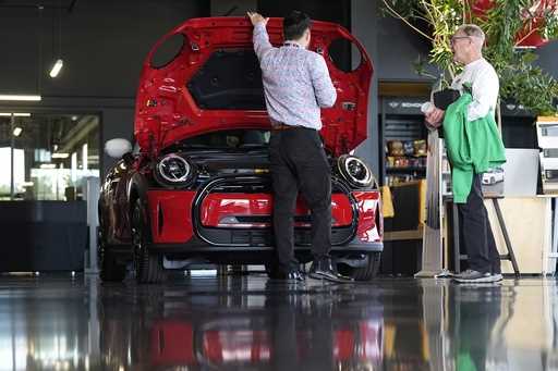 This photo provided by the Associated Press shows a salesperson shows an unsold 2024 Cooper SE elec…