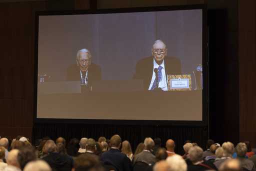 Shareholders watch Warren Buffett and Charlie Munger from the overflow room during the Berkshire Ha…
