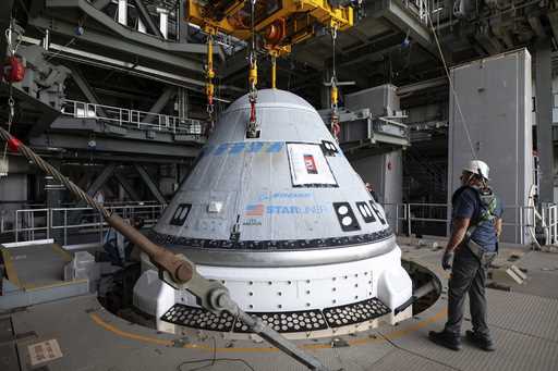 In this photo provided by NASA, the Boeing Starliner spacecraft is lifted at the Vertical Integrati…