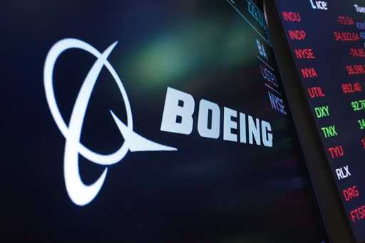 The logo for Boeing appears on a screen above a trading post on the floor of the New York Stock Exc…
