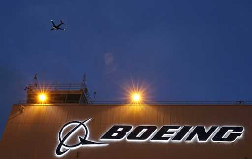 An airplane flies over a sign on Boeing's 737 delivery center, October 19, 2015, at Boeing Field in…