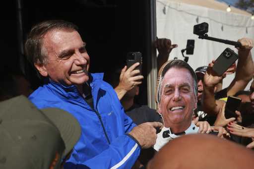 Brazil's former President Jair Bolsonaro points a photo of him during a motorcycle caravan by suppo…