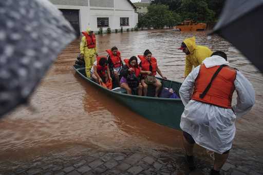 Firefighters evacuate people from a flooded area after heavy rain in Sao Sebastiao do Cai, Rio Gran…