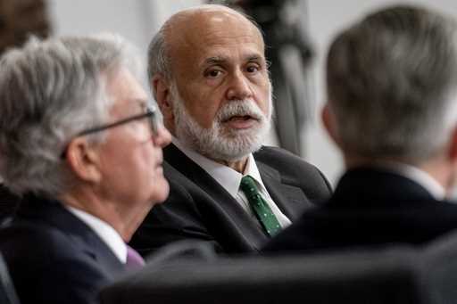 Former Federal Reserve Chairman Ben Bernanke, center, accompanied by Federal Reserve Chairman Jerom…