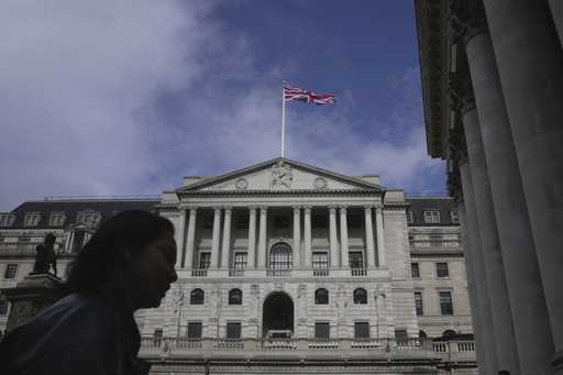 A woman walks in front of the Bank of England, at the financial district in London, on March 23, 20…