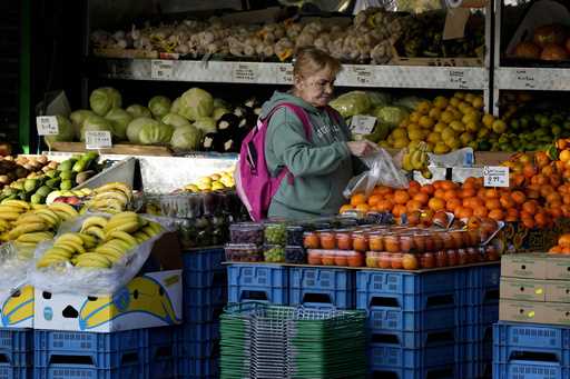 A woman selects fruits at a supermarket in London, on November 17, 2021