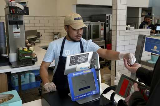 An employee collects payment at an Auntie Anne's and Cinnabon store in Livermore, Calif