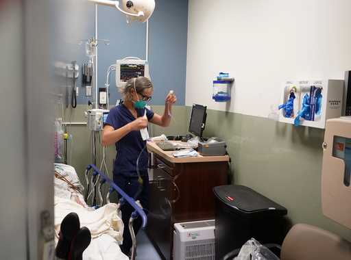 Registered nurse Sandra Younan sets up a new intravenous line for a patient under her care at Provi…