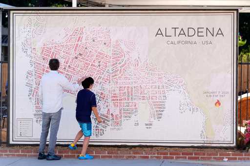 Sam Holtzman and his son Eibu, 9, residents of northwest Altadena, whose house still stands but rem…