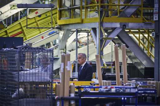 Prime Minister Mark Carney walks through a manufacturing facility ahead of a press conference in Mi…