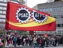 A flag flies as Public Service Alliance of Canada members walk the picket line outside government b…