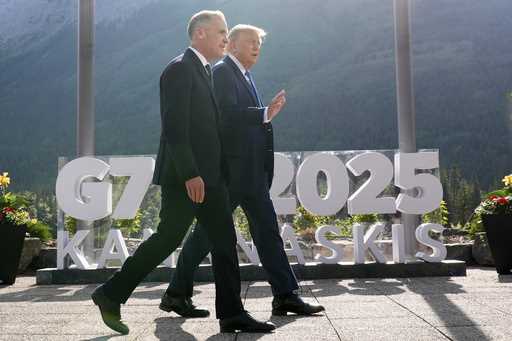 Canada's Prime Minister Mark Carney walks with President Donald Trump after a group photo at the G7…