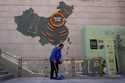 A cleaner sweeps near a map showing Evergrande development projects in China on a wall in an Evergr…