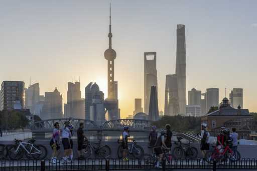 In this photo released by Xinhua News Agency, cyclists, some take selfie as they take rest against …