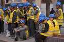 Workers wait for transport outside a construction site in Beijing, Tuesday, April 9, 2024