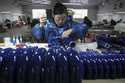 In this photo released by Xinhua News Agency, a worker assembles western musical instruments at a m…