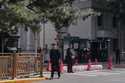 A man walks by Chinese security personnel guarding the entrance to the Jingxi Hotel where the Commu…