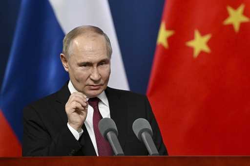 Russian President Vladimir Putin gestures as he talks with students of the Harbin Institute of Tech…
