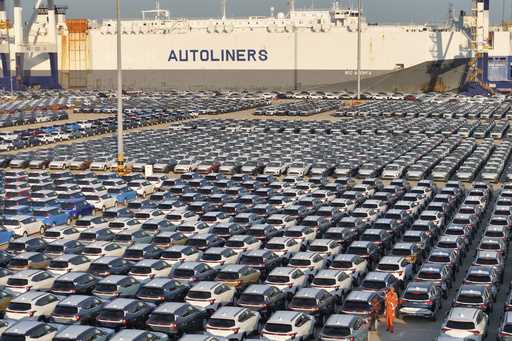 This aerial view shows new cars waiting to be exported at a dockyard in Yantai in eastern China's S…