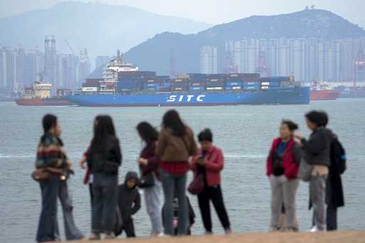 File - A container ship passes tourists in Xiamen in southeast China's Fujian province on December …