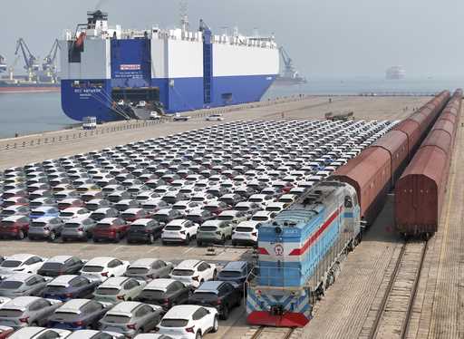 A freight train carrying cars to be exported arrives at a dock for ro-ro shipping in Yantai in east…