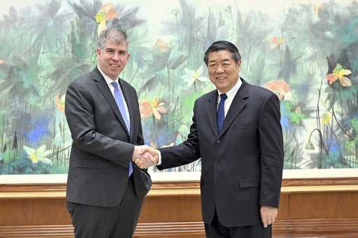 In this photo released by Xinhua News Agency, Chinese Vice Premier He Lifeng, right, shakes hands w…