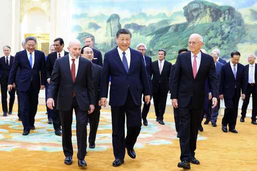 In this photo released by Xinhua News Agency, Chinese President Xi Jinping, center, walks with repr…