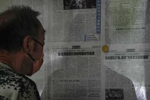 A man reads a Global Times newspaper carrying an article, center, that reads 