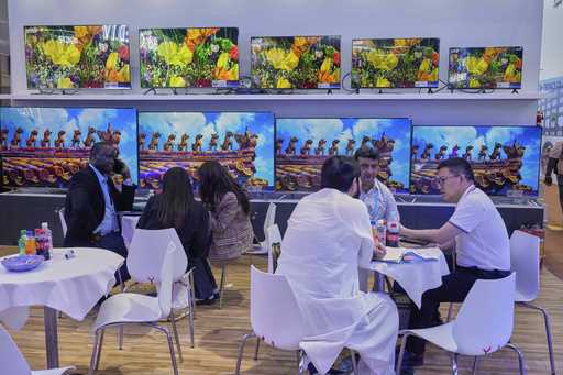 Visitors talk to a sale rep for televisions at the 137th Canton Fair, in Guangzhou in southern Chin…