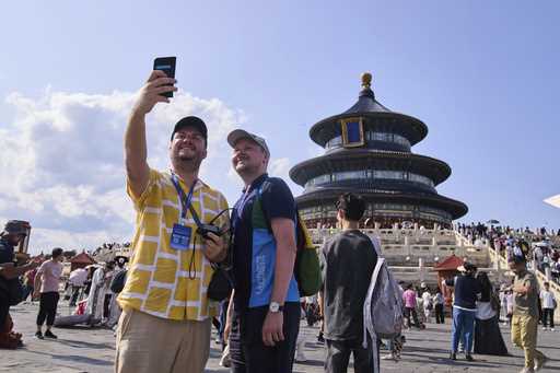 Tourists take a selfie at the Temple of Heaven as they take a half-day tour offering by a travel ag…