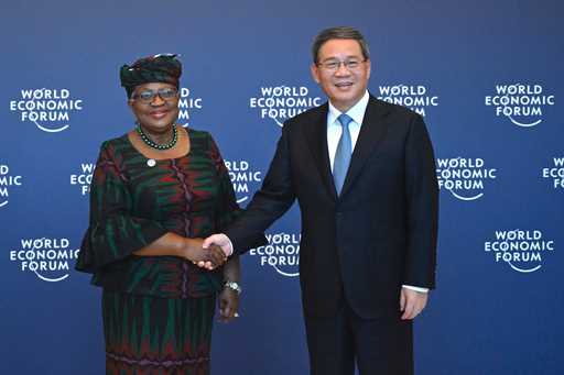 Chinese Premier Li Qiang, right, shakes hands with Director-General of the World Trade Organization…