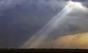 Sunlight filters through storm clouds onto a wind turbine as severe weather rolls through the midwe…